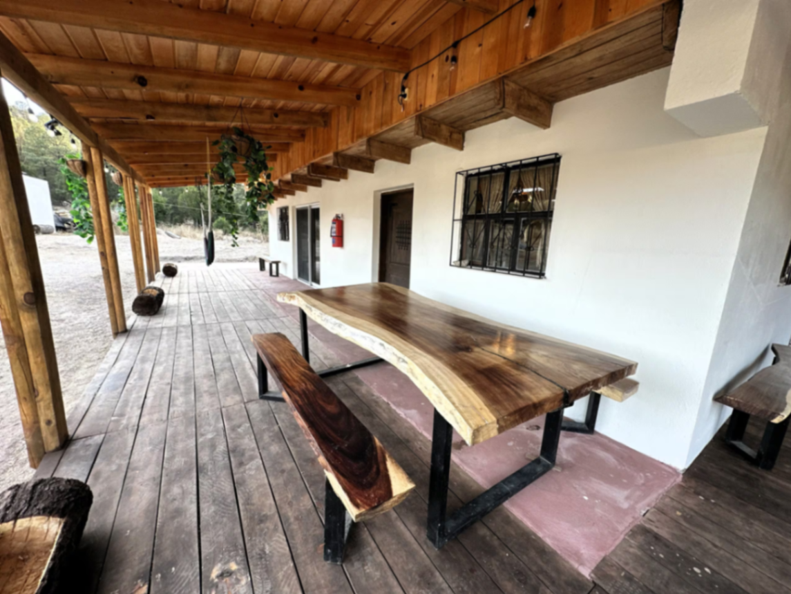 Área social con mesa de madera y terraza