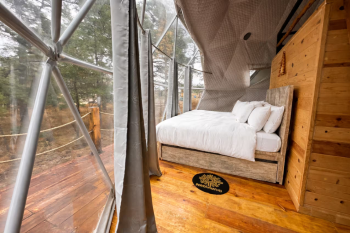 Cama matrimonial con vista al bosque